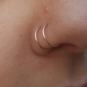 Single pierced rose gold double nose ring spiral